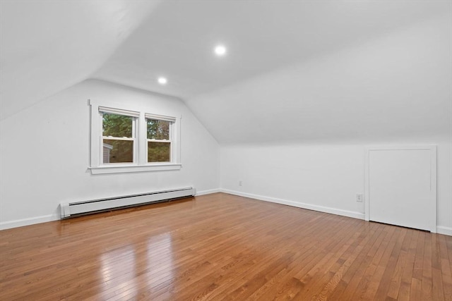 bonus room with a baseboard heating unit, hardwood / wood-style flooring, vaulted ceiling, baseboards, and recessed lighting