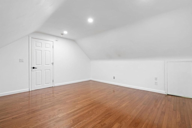 additional living space with wood finished floors, baseboards, lofted ceiling, and recessed lighting