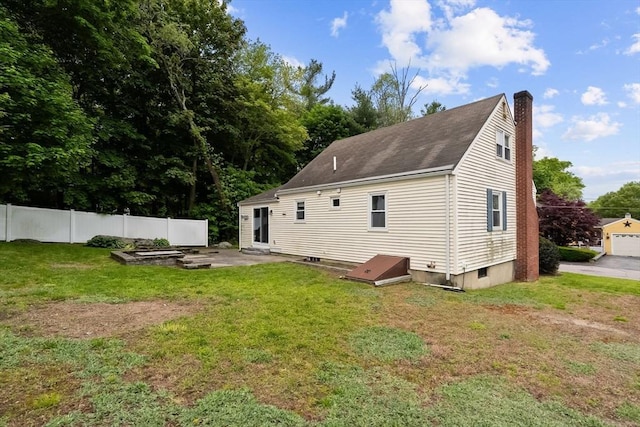 rear view of house with a chimney, a garden, and a patio