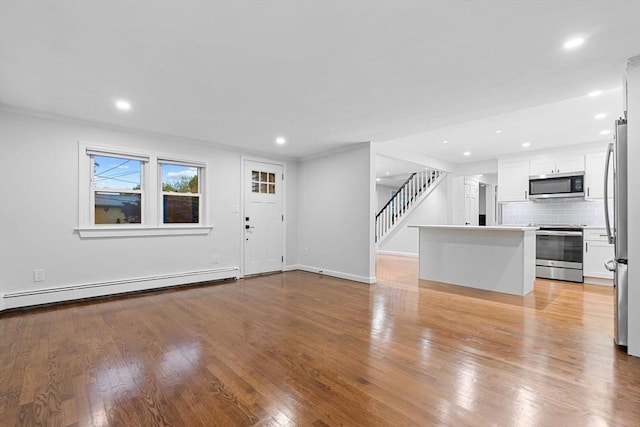 unfurnished living room featuring a baseboard radiator, light wood-type flooring, stairway, recessed lighting, and baseboards
