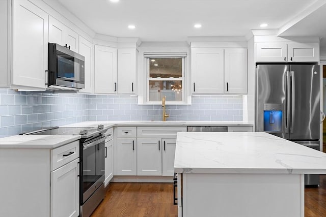 kitchen with stainless steel appliances, a sink, decorative backsplash, dark wood-style flooring, and recessed lighting
