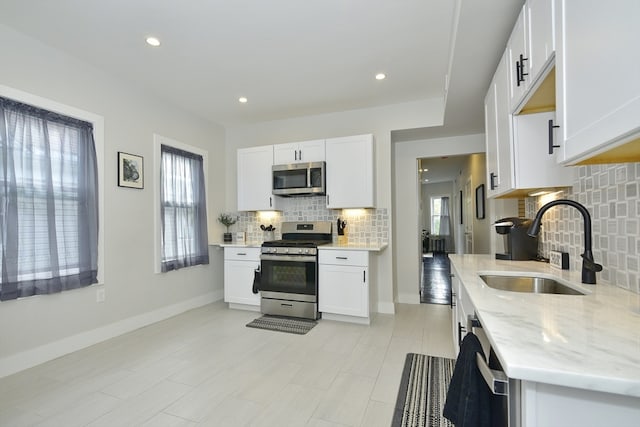 kitchen featuring white cabinets, appliances with stainless steel finishes, and sink