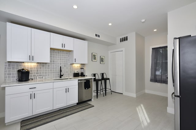 kitchen featuring white cabinetry, sink, and appliances with stainless steel finishes