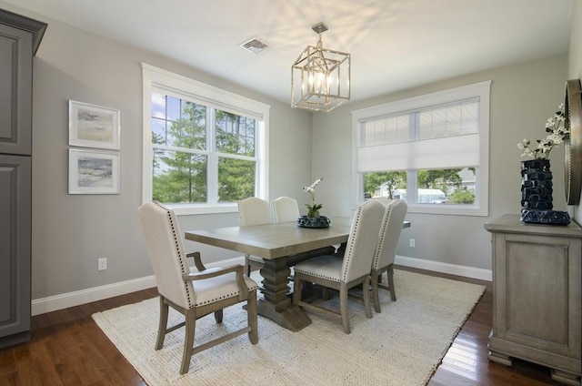 dining space featuring an inviting chandelier and dark hardwood / wood-style flooring