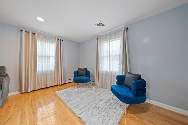 sitting room with wood-type flooring and a healthy amount of sunlight