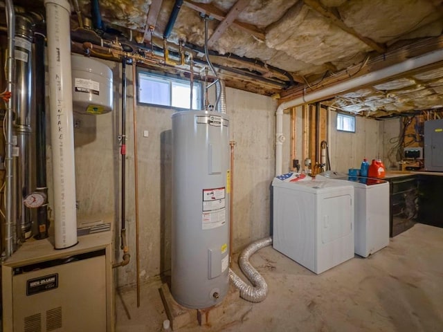 basement featuring washer and clothes dryer, electric panel, and electric water heater