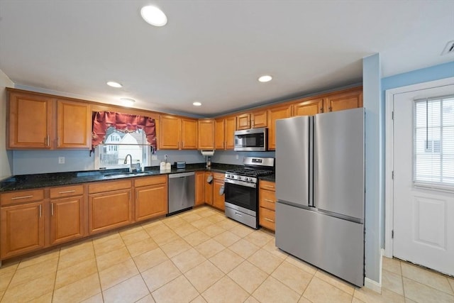 kitchen featuring a healthy amount of sunlight, appliances with stainless steel finishes, sink, and light tile patterned flooring