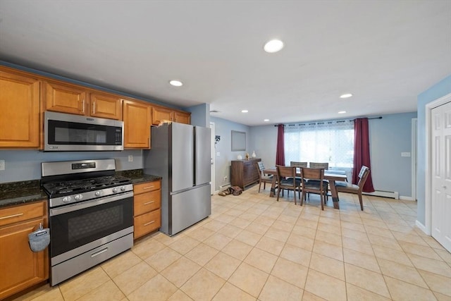 kitchen featuring dark stone countertops, light tile patterned floors, and stainless steel appliances