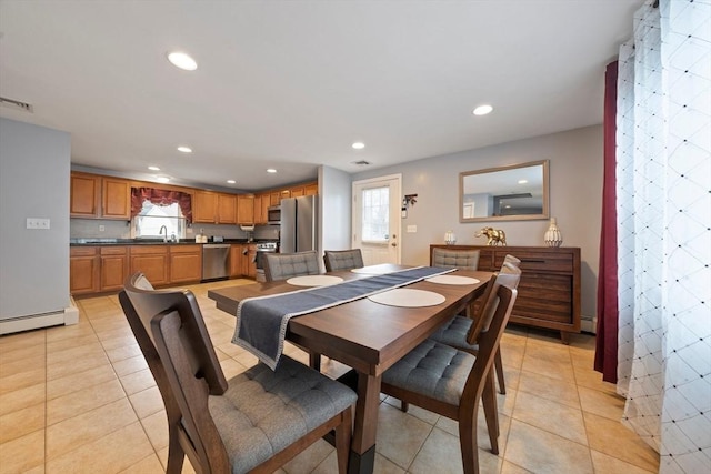 dining space featuring sink, light tile patterned floors, and a baseboard radiator