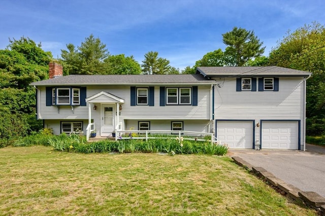 146 Field St, Taunton, MA 02780 - bi-level home with asphalt driveway, a chimney, a garage, and a front lawn