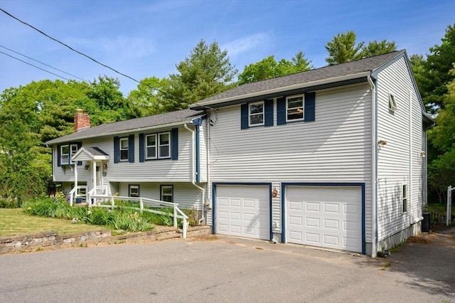 146 Field St, Taunton, MA 02780 - bi-level home with an attached garage, asphalt driveway, and a chimney