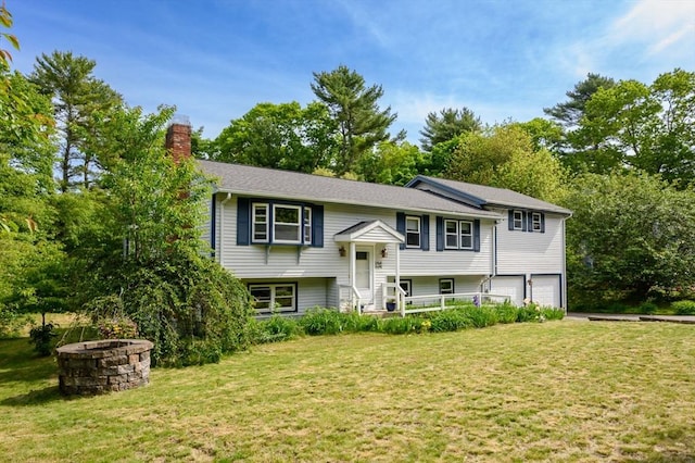 146 Field St, Taunton, MA 02780 - split foyer home featuring a chimney, an attached garage, an outdoor fire pit, a front yard, and view of scattered trees