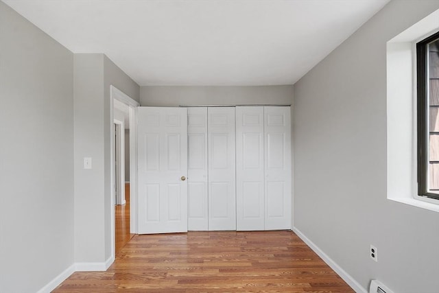5 Washington St Unit D2, Reading, MA 01867 - unfurnished bedroom featuring light wood finished floors, baseboards, and a closet
