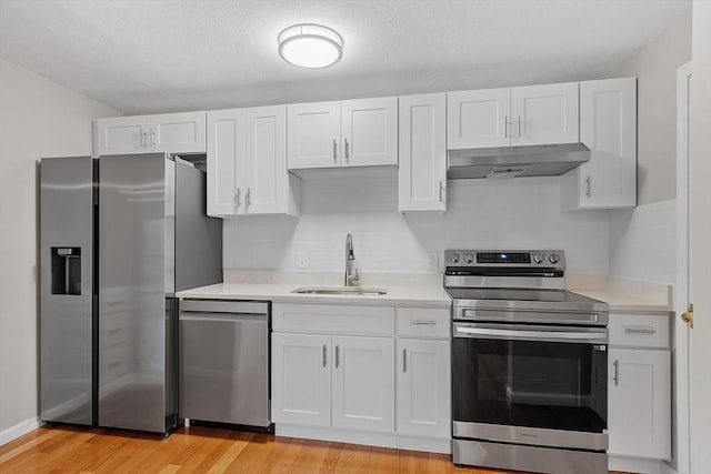 5 Washington St Unit D2, Reading, MA 01867 - kitchen featuring appliances with stainless steel finishes, under cabinet range hood, a sink, and light countertops