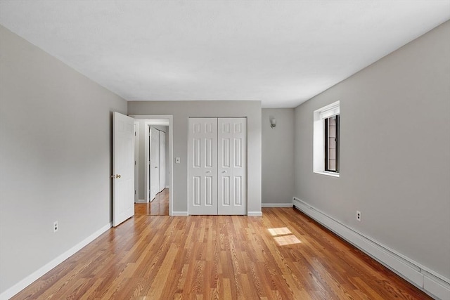 5 Washington St Unit D2, Reading, MA 01867 - unfurnished bedroom with a baseboard radiator, light wood finished floors, and baseboards