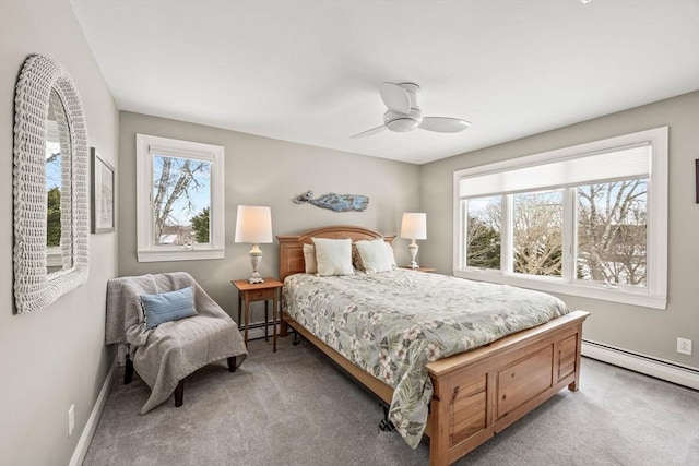 bedroom with a baseboard heating unit, light carpet, ceiling fan, and baseboards