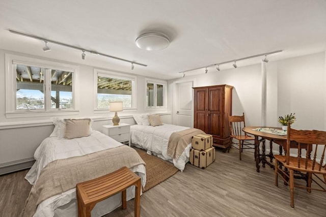 bedroom with light wood-style flooring and track lighting