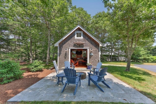 view of patio with a fire pit and an outdoor structure