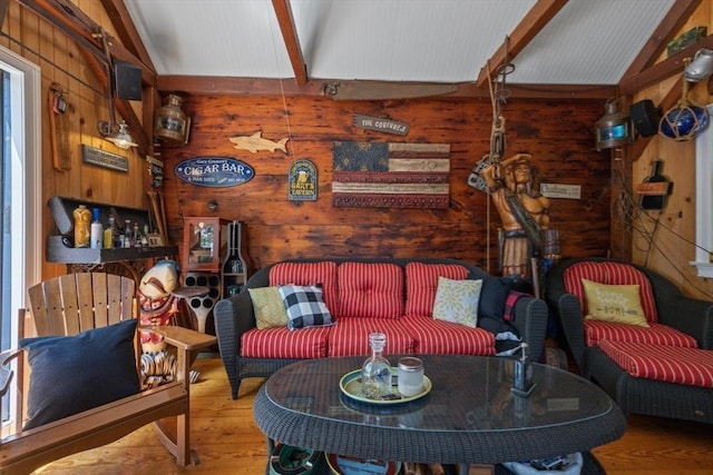 living area featuring vaulted ceiling with beams, wooden walls, and wood finished floors