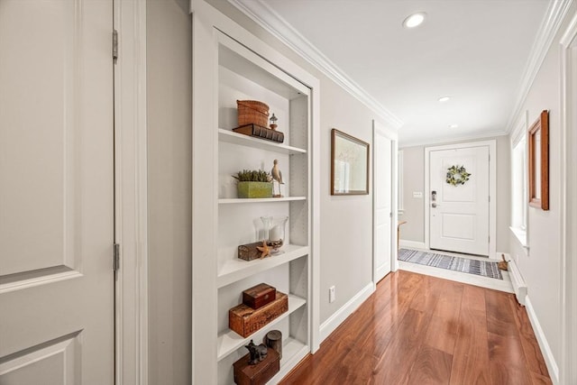 doorway featuring dark wood-style floors, baseboards, built in shelves, and ornamental molding