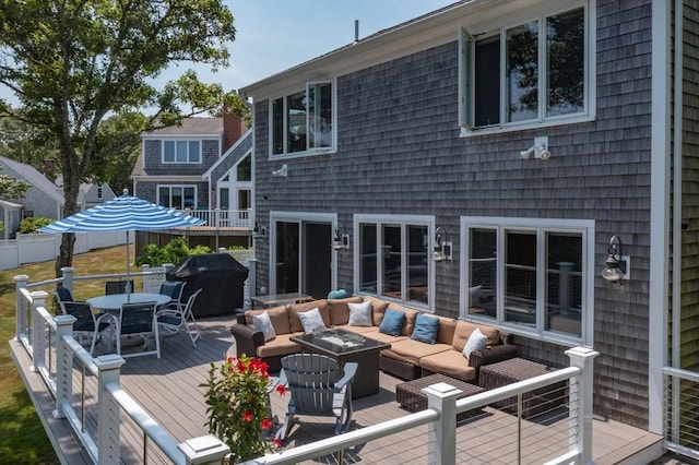 wooden deck with outdoor dining space, area for grilling, and an outdoor living space