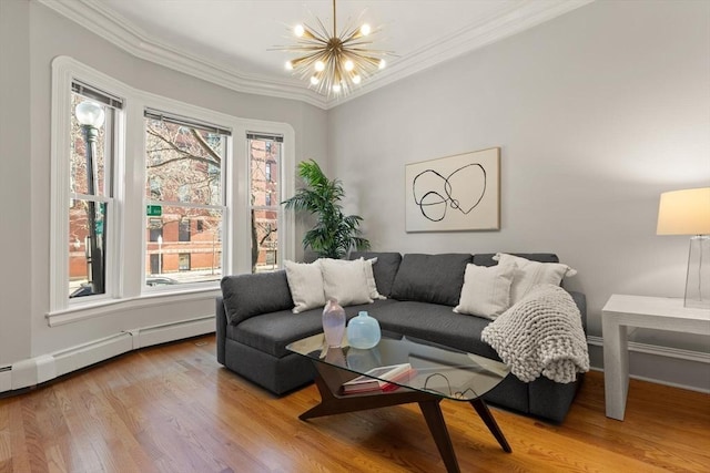 living room featuring a baseboard heating unit, light hardwood / wood-style flooring, ornamental molding, and a notable chandelier