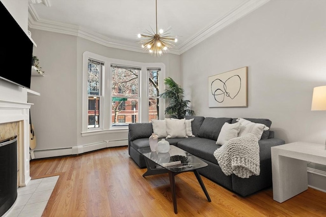 living room featuring a notable chandelier, baseboard heating, a wealth of natural light, and a tiled fireplace