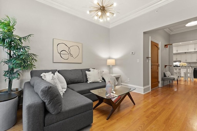 living room featuring light hardwood / wood-style flooring, ornamental molding, and a notable chandelier