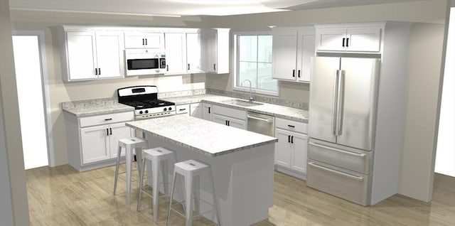 kitchen with white cabinets, a kitchen island, stainless steel appliances, sink, and a breakfast bar area