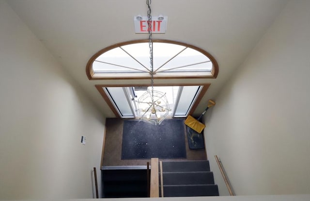 stairway with a chandelier