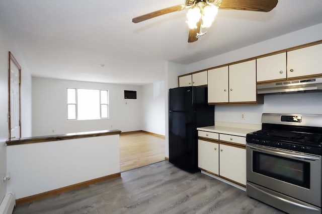 kitchen featuring light countertops, gas stove, freestanding refrigerator, open floor plan, and under cabinet range hood