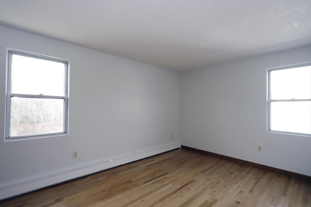 unfurnished room with light wood-style floors, baseboards, and baseboard heating