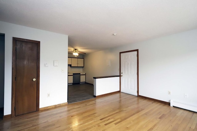 unfurnished living room featuring a baseboard radiator, light wood-style flooring, and baseboards