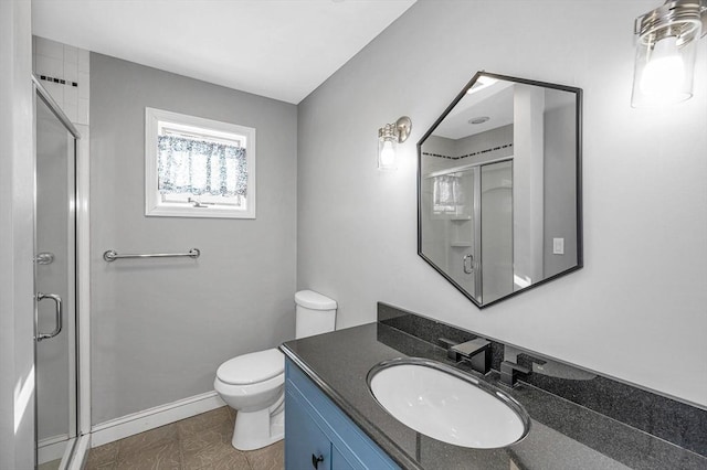 bathroom featuring vanity, toilet, and a shower with shower door