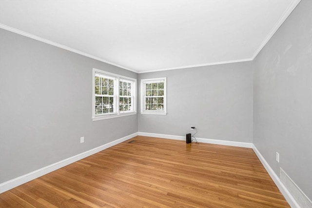 empty room featuring ornamental molding and light wood-type flooring