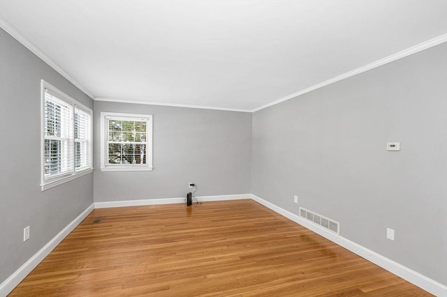 empty room featuring crown molding and light hardwood / wood-style flooring