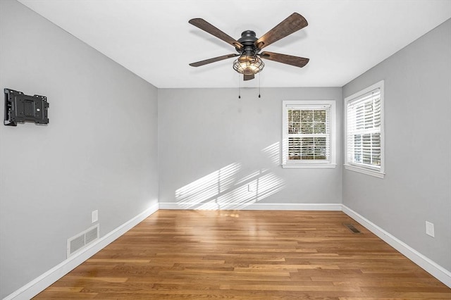 empty room with hardwood / wood-style flooring and ceiling fan