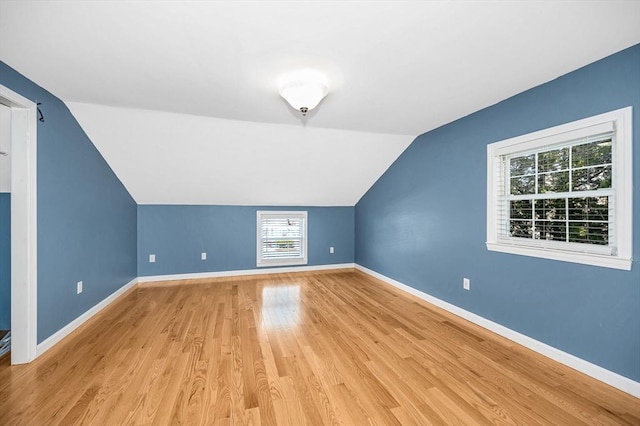 bonus room with lofted ceiling and light wood-type flooring