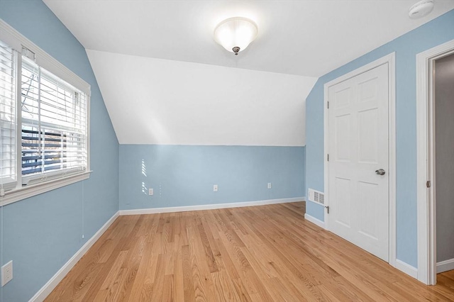 bonus room with vaulted ceiling and light hardwood / wood-style flooring