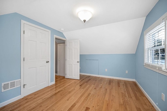 bonus room with lofted ceiling and light wood-type flooring