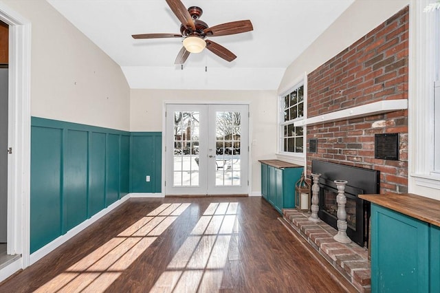 unfurnished living room featuring dark hardwood / wood-style flooring, vaulted ceiling, french doors, and ceiling fan