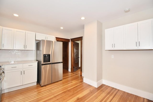 130 Center St, Ludlow, MA 01056 - kitchen featuring stainless steel fridge with ice dispenser, light countertops, light wood-type flooring, white cabinetry, and recessed lighting
