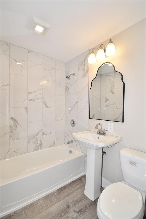 130 Center St, Ludlow, MA 01056 - bathroom with toilet, shower / washtub combination, and wood finished floors