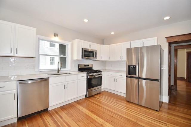 130 Center St, Ludlow, MA 01056 - kitchen featuring stainless steel appliances, a sink, light countertops, white cabinets, and recessed lighting