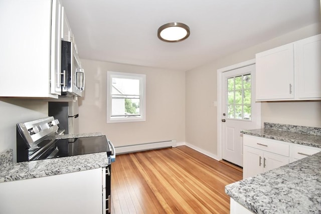 130 Center St, Ludlow, MA 01056 - kitchen with stainless steel appliances, a baseboard heating unit, white cabinets, light wood finished floors, and baseboards