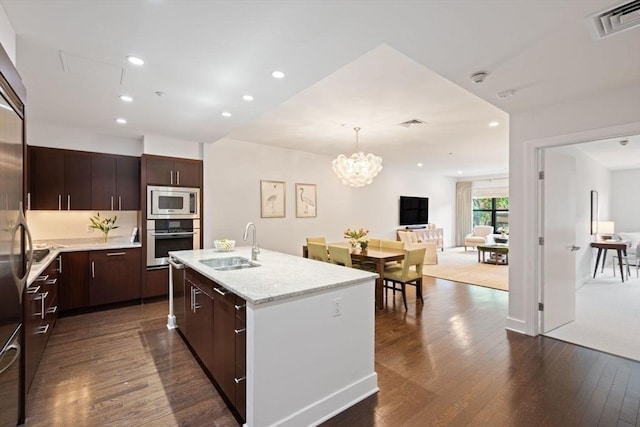 kitchen featuring visible vents, appliances with stainless steel finishes, a sink, dark wood-style floors, and an inviting chandelier