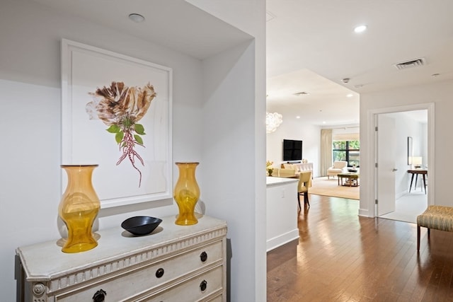 hall featuring hardwood / wood-style flooring and a chandelier