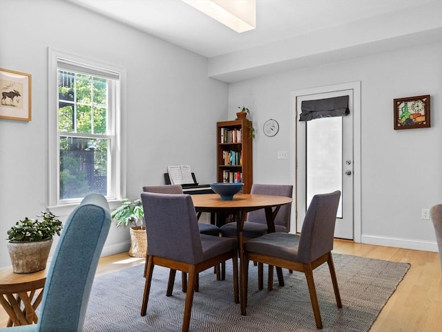 dining area with light wood finished floors and a skylight