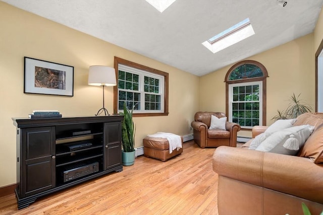 19 Birch St, Millis, MA 02054 - living room featuring a skylight, light wood finished floors, vaulted ceiling, a baseboard radiator, and healthy amount of natural light