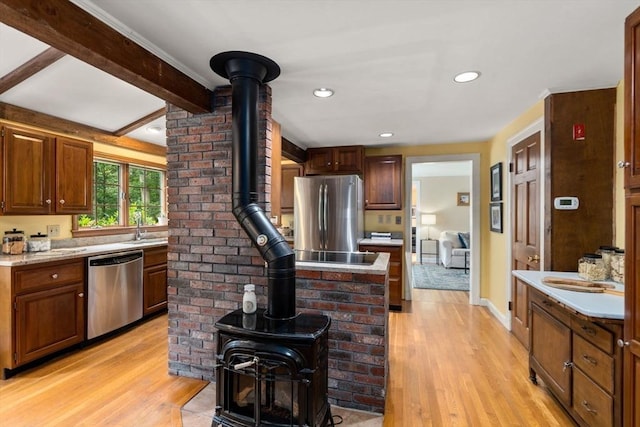 19 Birch St, Millis, MA 02054 - kitchen with appliances with stainless steel finishes, a wood stove, light wood-style flooring, light countertops, and recessed lighting